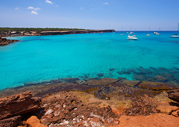 Private charter yachts in the turquoise waters of Cala Saona in Formentera